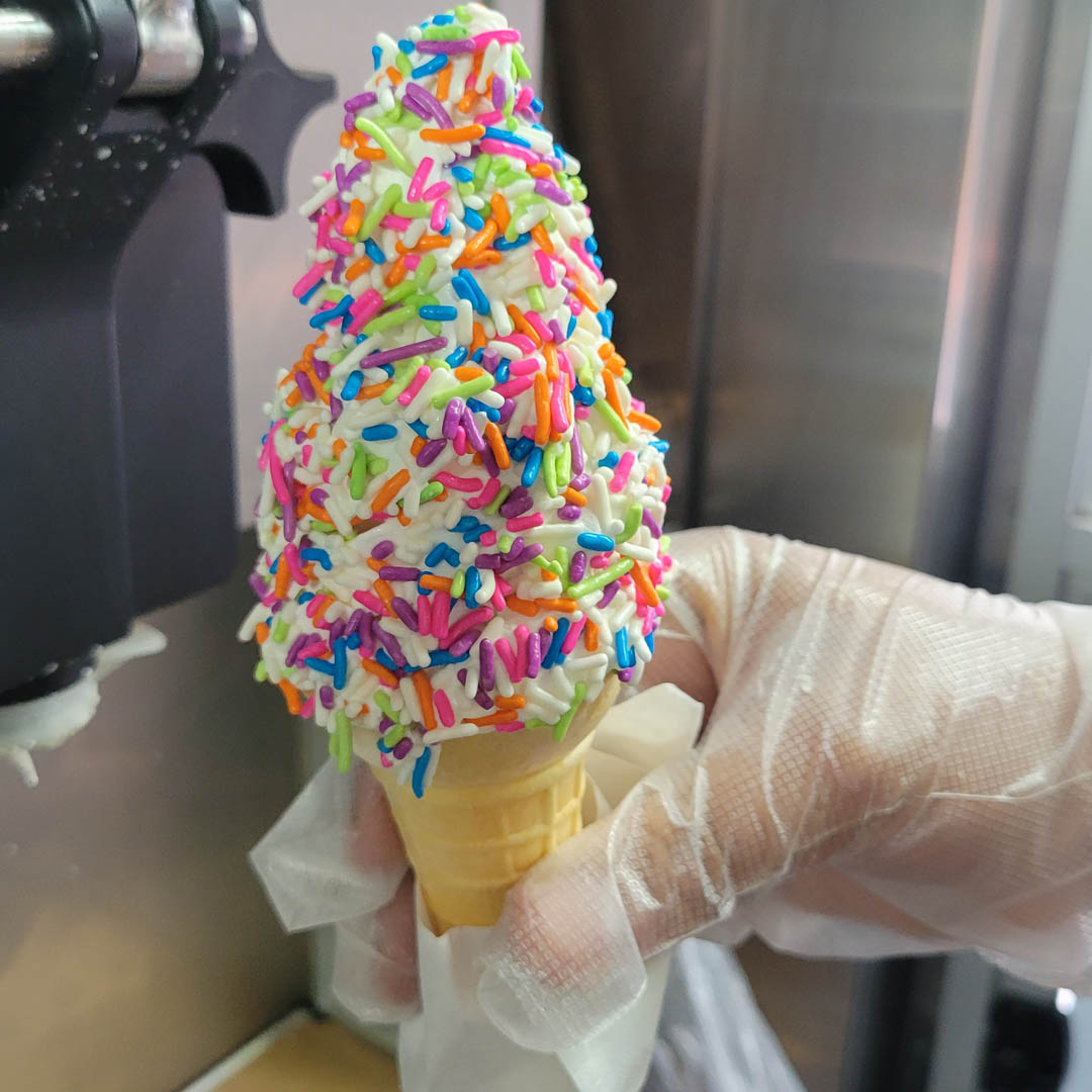 Rainbow sprinkles soft ice cream cone